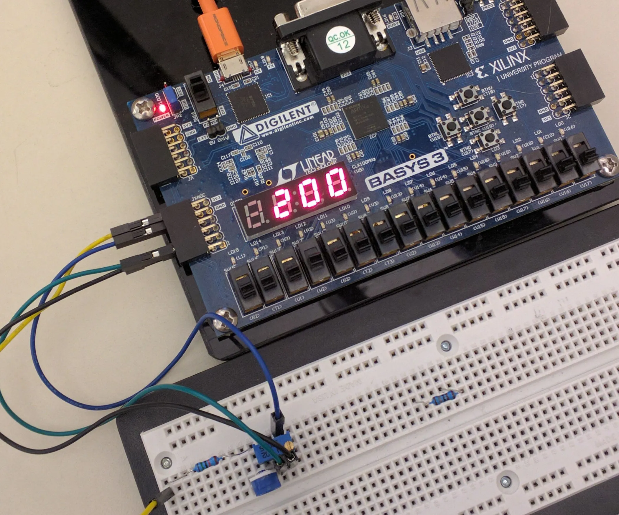 Basys 3 FPGA board wired to a breadboard, running a digital counter